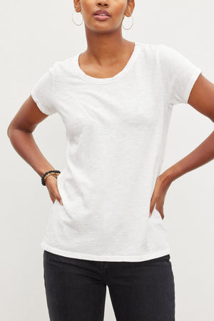 Person wearing a TILLY TEE by Velvet by Graham & Spencer in soft cotton slub and black jeans, standing with their hands on their hips.