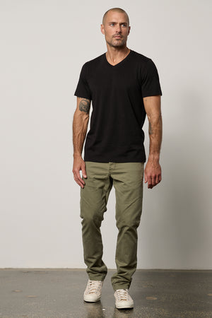 a man wearing MARSHALL V-NECK TEE by Velvet by Graham & Spencer pants and a black t-shirt.