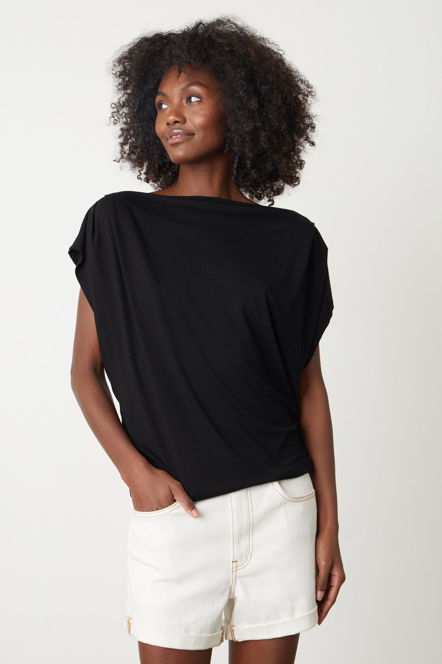 A woman wearing a Velvet by Graham & Spencer PAULINA VISCOSE JERSEY TOP and white shorts.-26577314808001