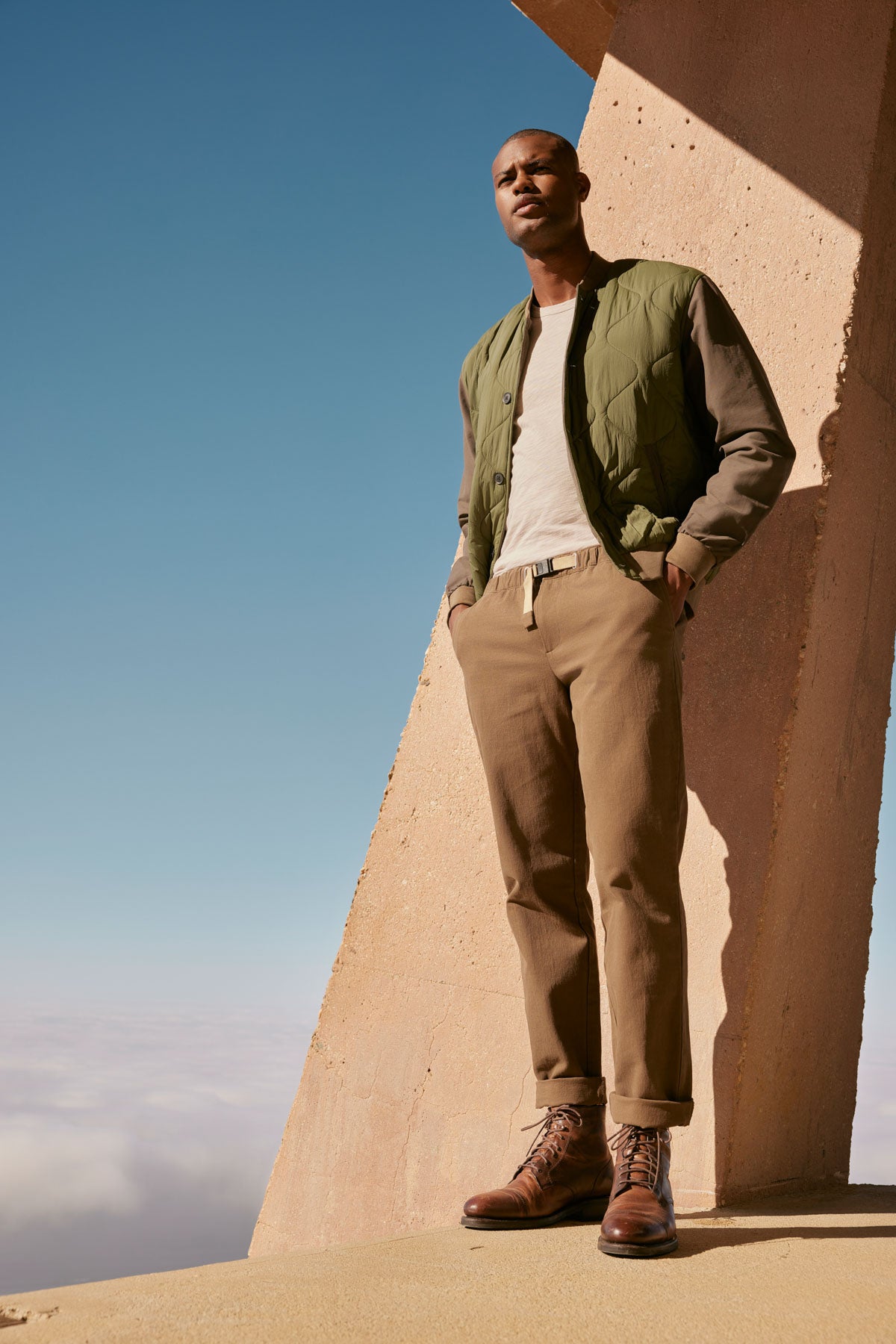 A man in a Velvet by Graham & Spencer MAISON QUILTED JACKET standing on top of a building.-35605815328961