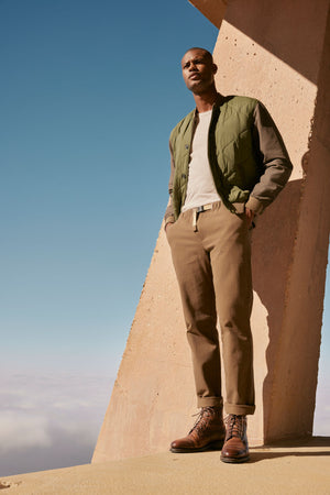 A man in a Velvet by Graham & Spencer MAISON QUILTED JACKET standing on top of a building.
