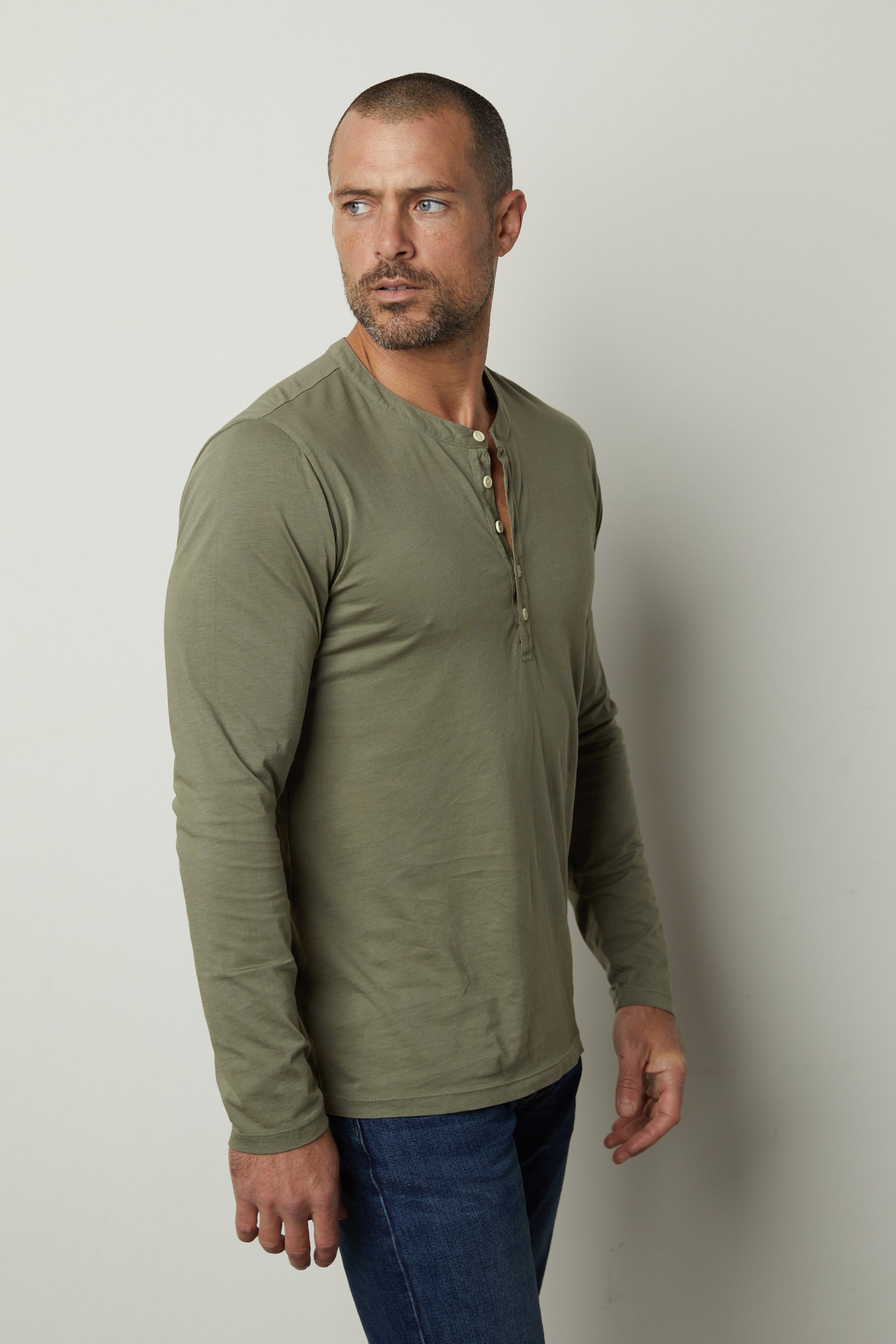 A man wearing a cactus green Velvet by Graham & Spencer ALVARO COTTON JERSEY HENLEY long sleeve henley tee