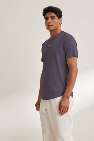 A person stands against a plain background wearing the Velvet by Graham & Spencer