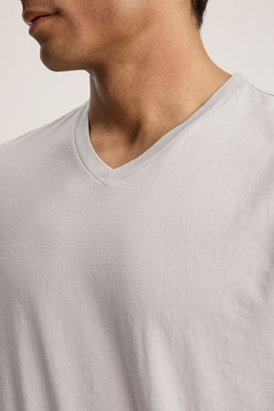 The SAMSEN TEE by Velvet by Graham & Spencer is a light grey V-neck Pima jersey T-shirt. Its smooth texture and subtle drape accentuate the classic neckline against a neutral background, ideal for effortless layering.