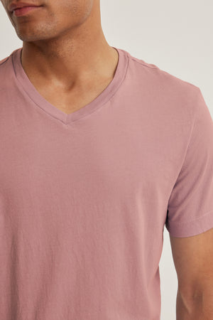 A person wears the SAMSEN TEE by Velvet by Graham & Spencer—a light mauve, V-neck Pima jersey top—shown from shoulders to above the waist, perfect for everyday wear.