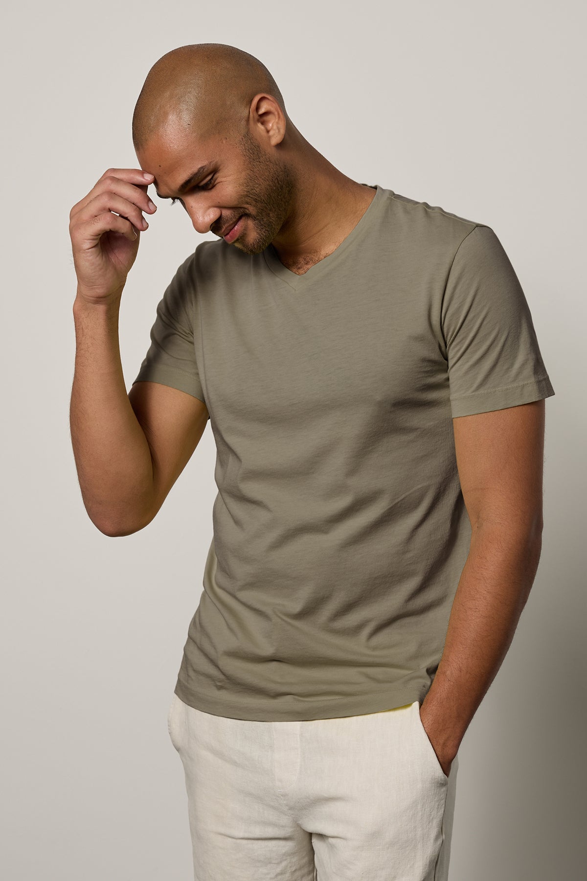 A man wearing a green Velvet by Graham & Spencer SAMSEN WHISPER CLASSIC V-NECK TEE.
