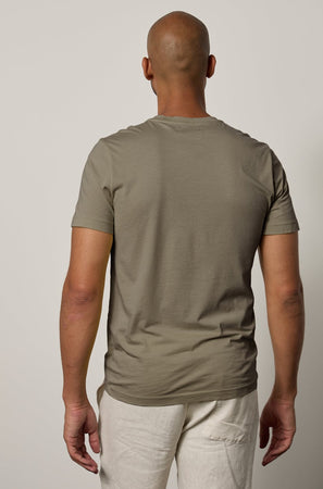 The back view of a man wearing a Velvet by Graham & Spencer SAMSEN WHISPER CLASSIC V-NECK TEE.
