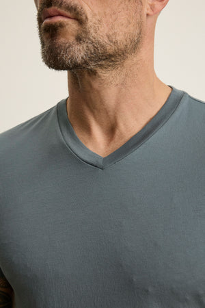 Close-up of a man with a beard wearing the Velvet by Graham & Spencer SAMSEN TEE, a gray Pima jersey V-neck T-shirt, showing only his neck, chin, and upper chest—ideal for effortless layering.