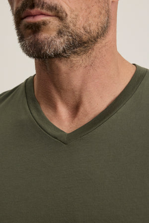 Close-up of a man's lower face, neck, and upper chest wearing the SAMSEN TEE by Velvet by Graham & Spencer—an olive green Pima jersey V-neckline tee ideal for everyday wear.