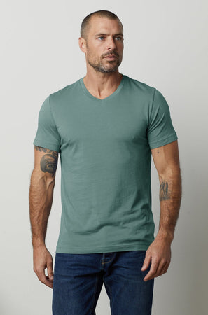 a man wearing a green Velvet by Graham & Spencer SAMSEN WHISPER CLASSIC V-NECK TEE.