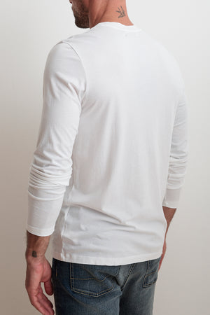 A guy in the SKEETER TEE by Velvet by Graham & Spencer and jeans, facing away from the camera. A subtle neck tattoo adds style and versatility.