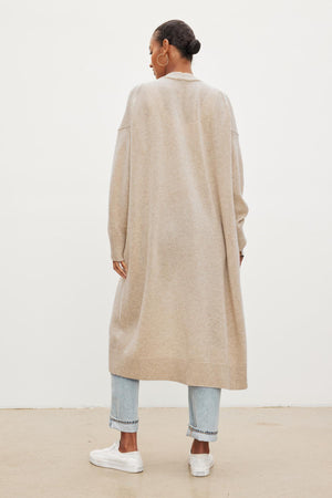 The view of a woman wearing a Velvet by Graham & Spencer LISA WOOL CASHMERE DUSTER CARDIGAN in beige.