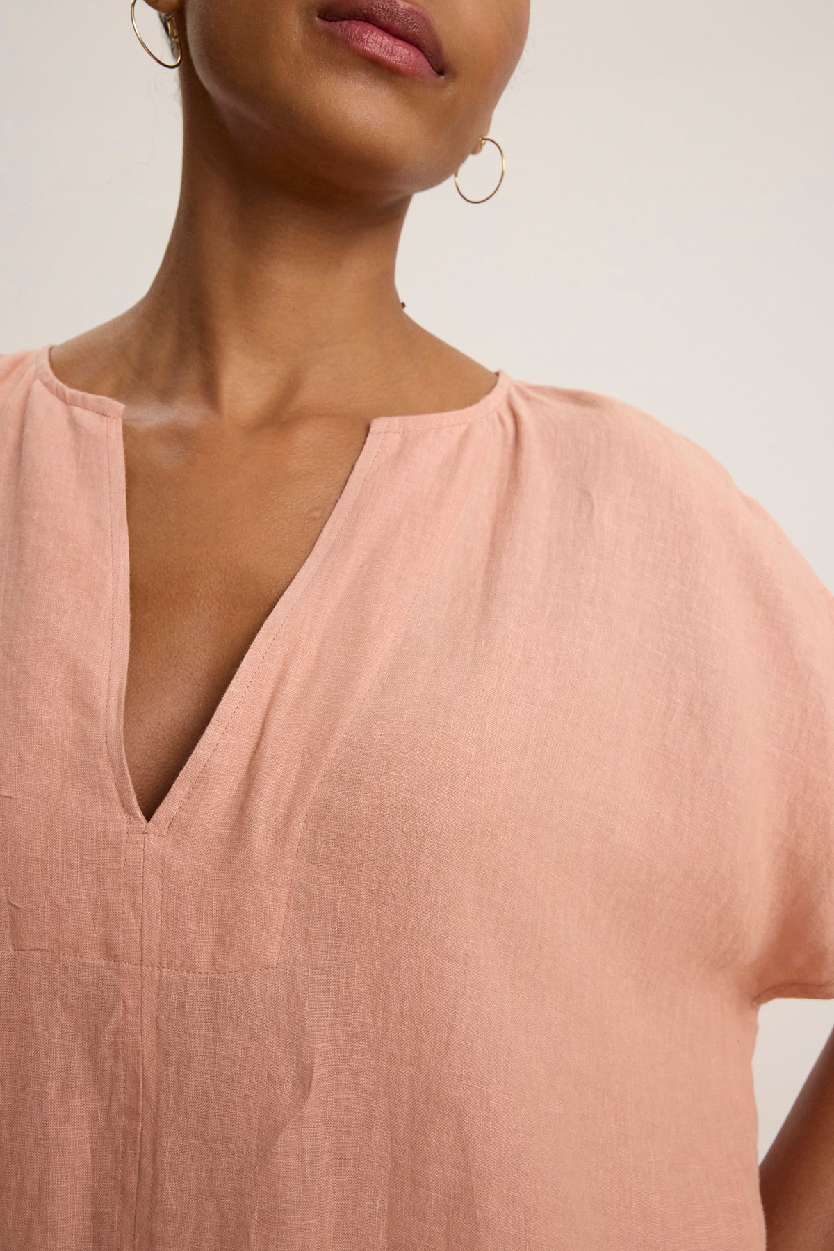 A person wearing the MAEVE LINEN DRESS by Velvet by Graham & Spencer, shown from the shoulders up—perfect for casual outings.-39148737822913