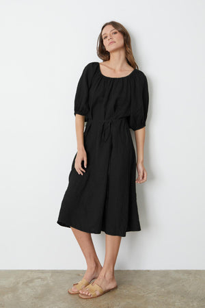 A person wearing a Velvet by Graham & Spencer Elly Linen Midi Dress and sandals.