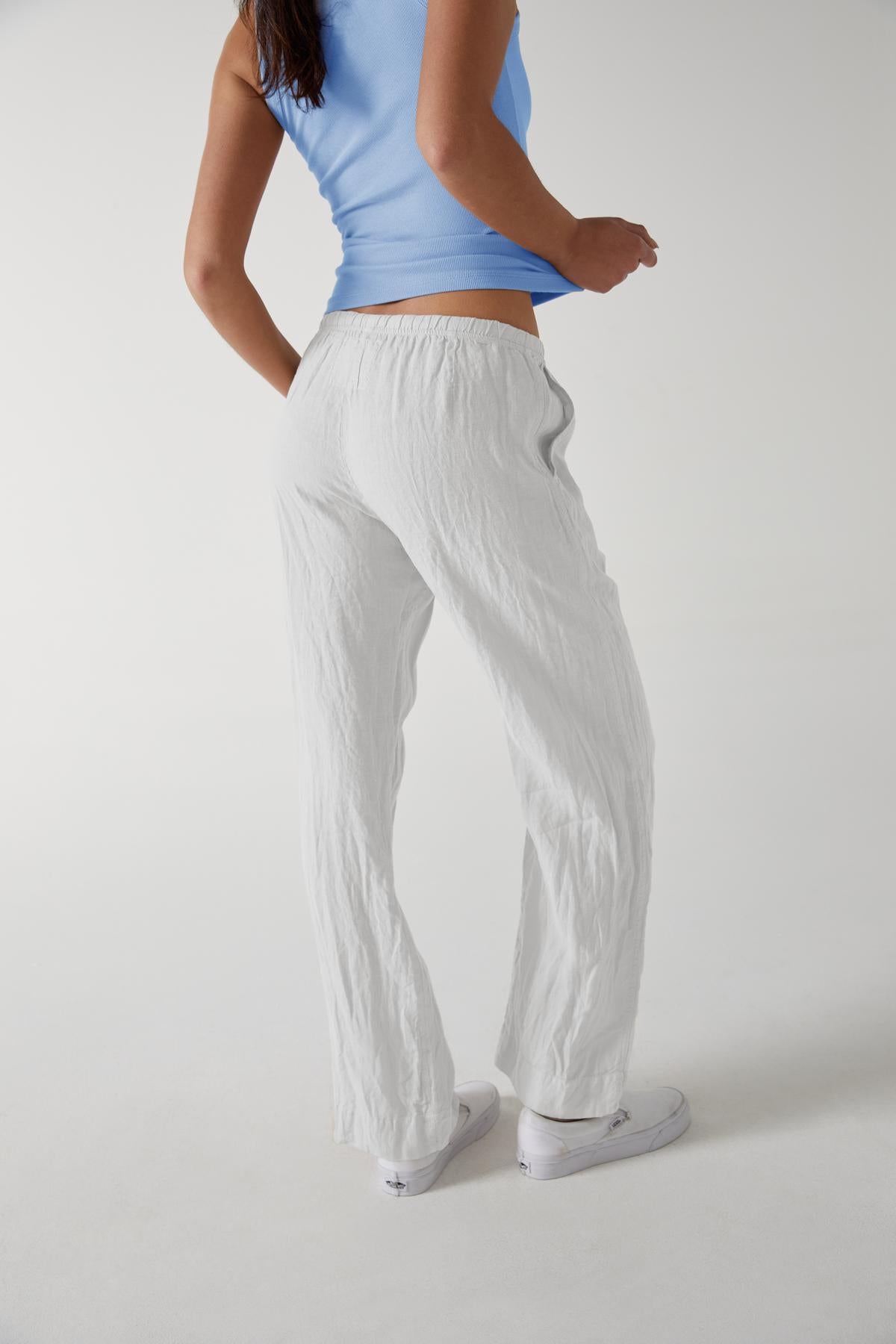   A woman wearing white Velvet by Jenny Graham PICO pants and a blue top. 