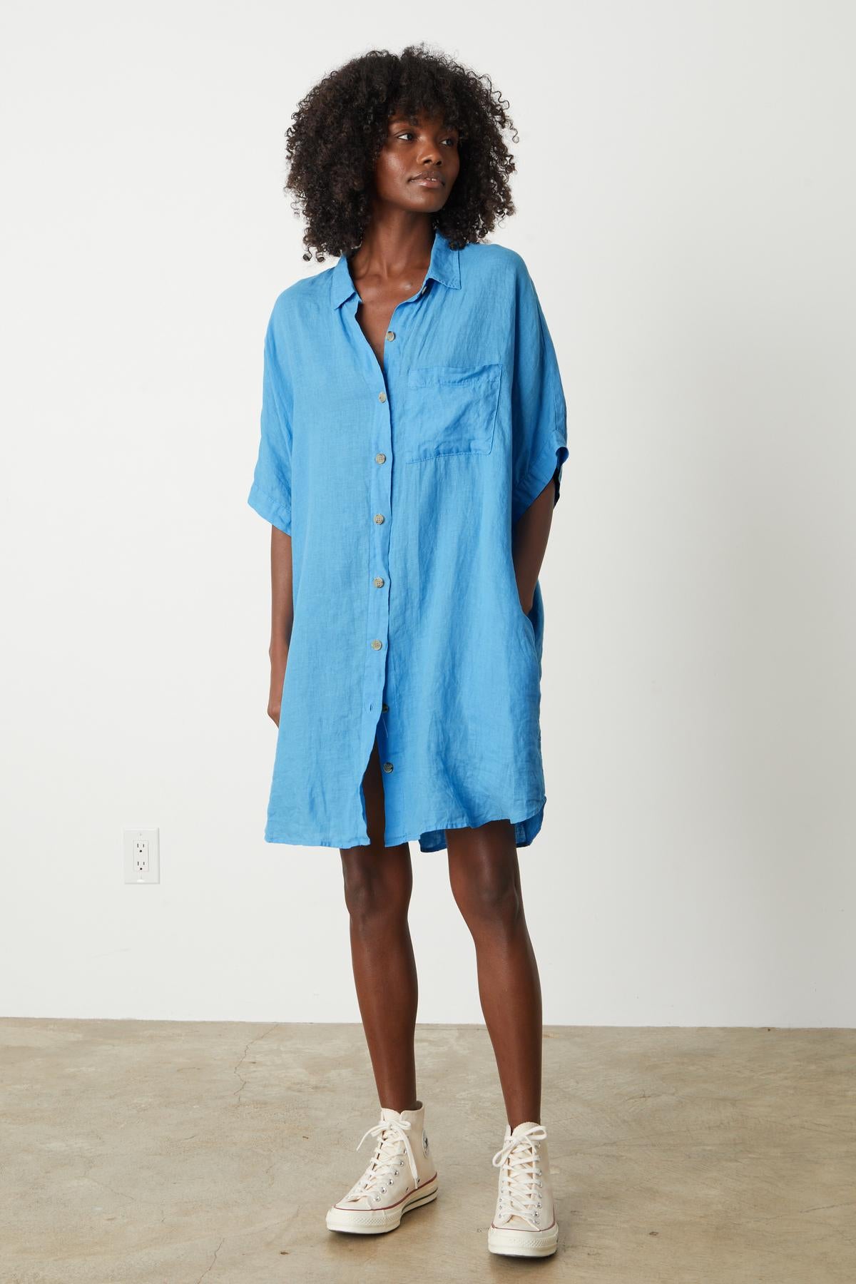 A woman wearing a Velvet by Graham & Spencer Stevie Linen Button-Up Dress and sneakers.-26544325853377