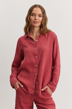 Woman in a casual red Willow Linen Button-Up shirt and matching pants, standing against a neutral background, looking directly at the camera with a slight smile. (Brand: Velvet by Graham & Spencer)