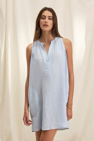 Someone is wearing a loose, light blue ADRIANA LINEN DRESS by Velvet by Graham & Spencer against a plain, light background.