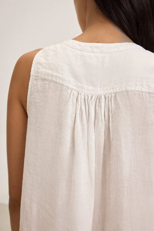 A person is seen from behind wearing the ADRIANA Linen Dress by Velvet by Graham & Spencer, featuring a loose fit with gathered fabric details at the back and a subtle V-neckline.
