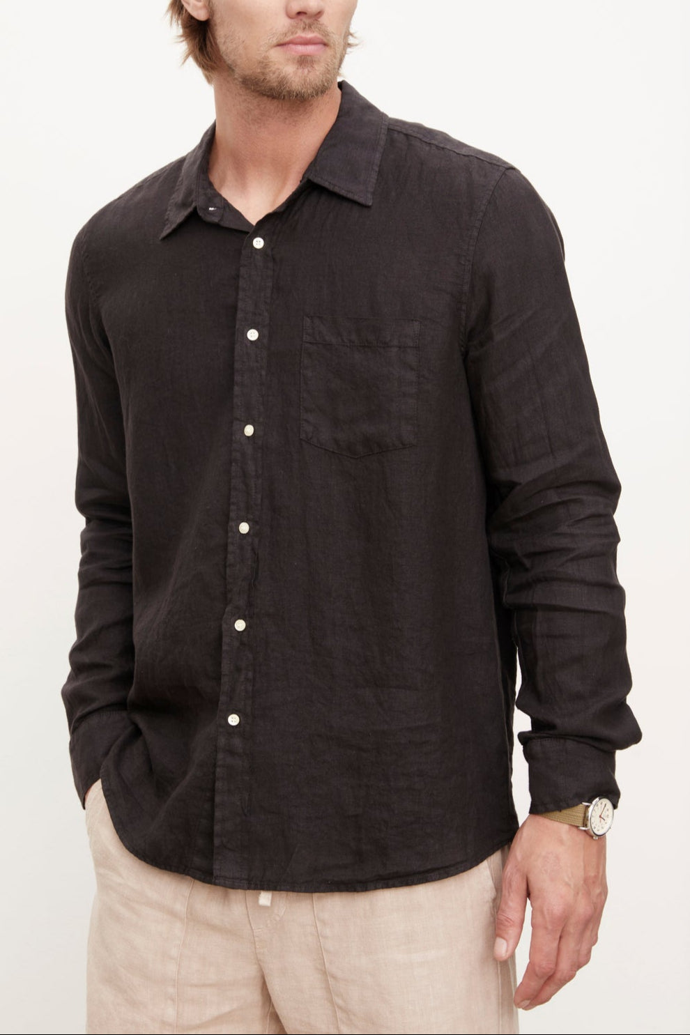 A stylish man wearing a Velvet by Graham & Spencer men's Benton linen button-up shirt with khaki pants.-36009360457921