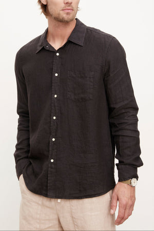 A stylish man wearing a Velvet by Graham & Spencer men's Benton linen button-up shirt with khaki pants.