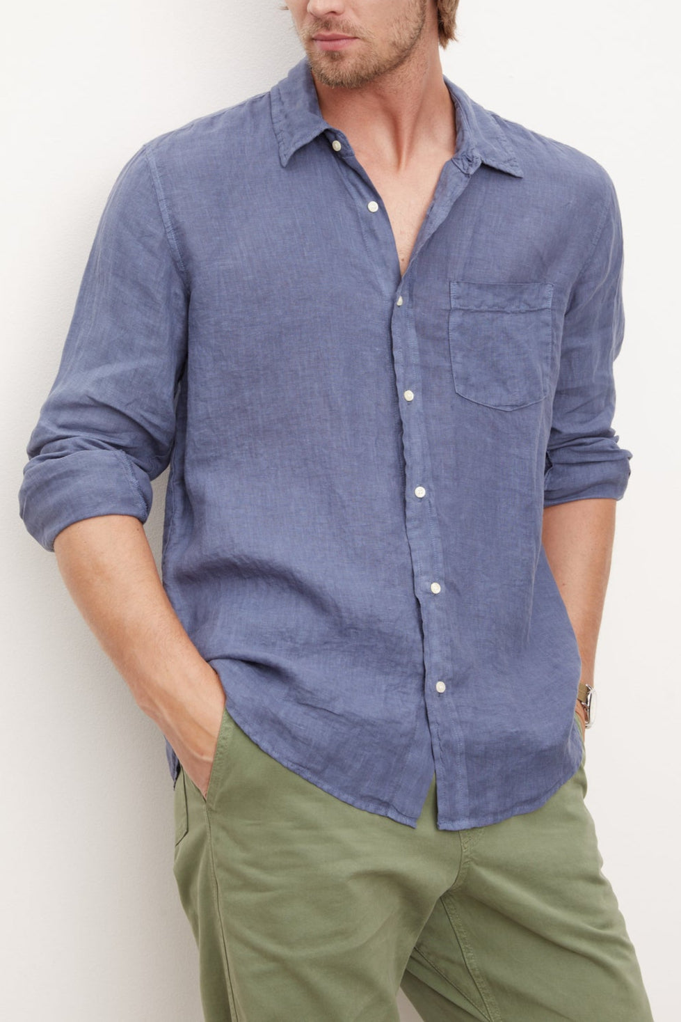 A stylish man in a Velvet by Graham & Spencer men's blue woven Benton Linen Button-Up Shirt leaning against a wall.-36009360588993