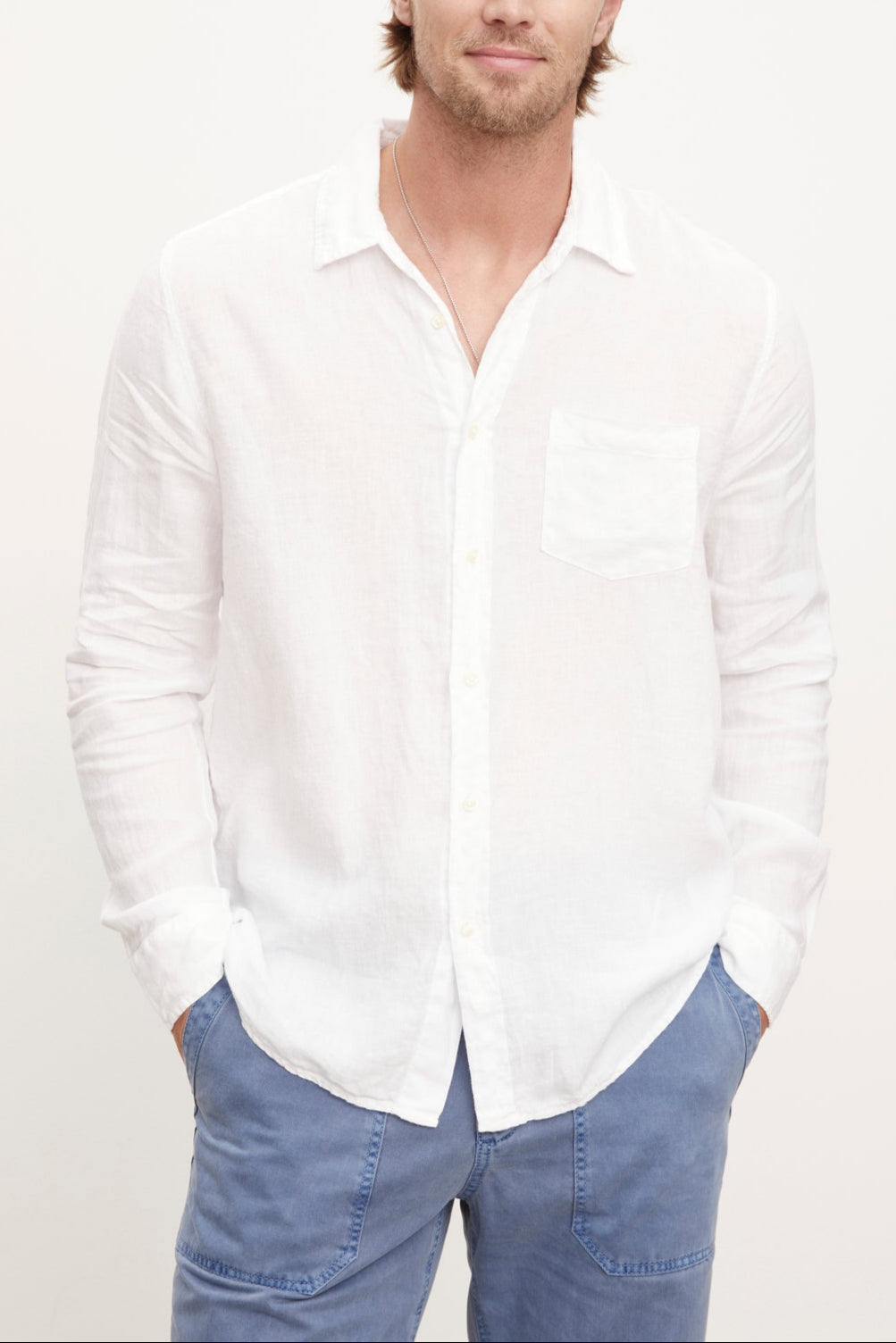 A stylish man wearing a Velvet by Graham & Spencer BENTON LINEN BUTTON-UP SHIRT and blue pants.-36009360130241