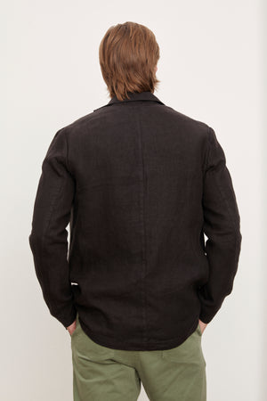 The back of a man wearing a Velvet by Graham & Spencer JOSHUA LINEN BLAZER and green pants.