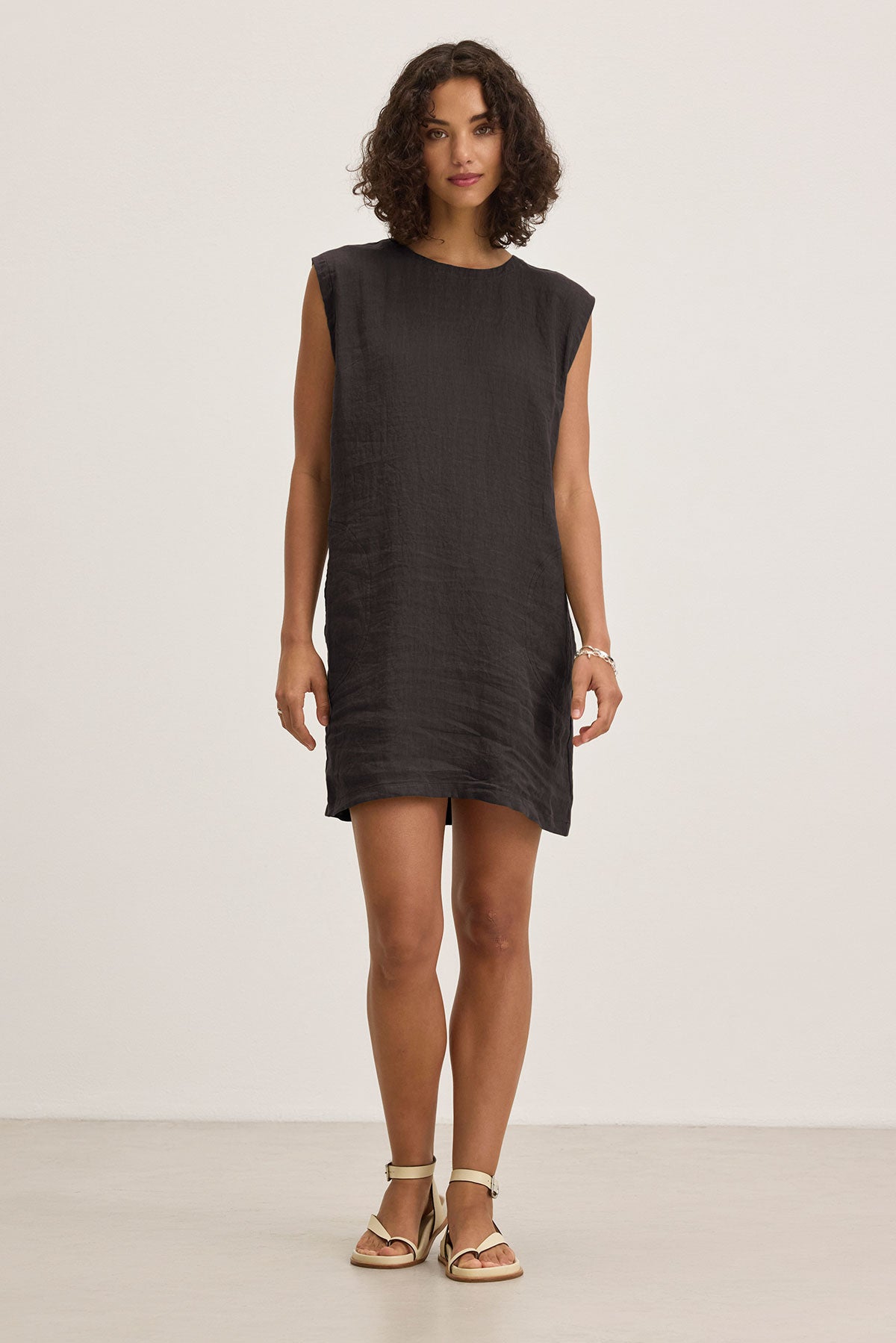 A person in the LARA LINEN DRESS by Velvet by Graham & Spencer and sandals stands against a plain white background.