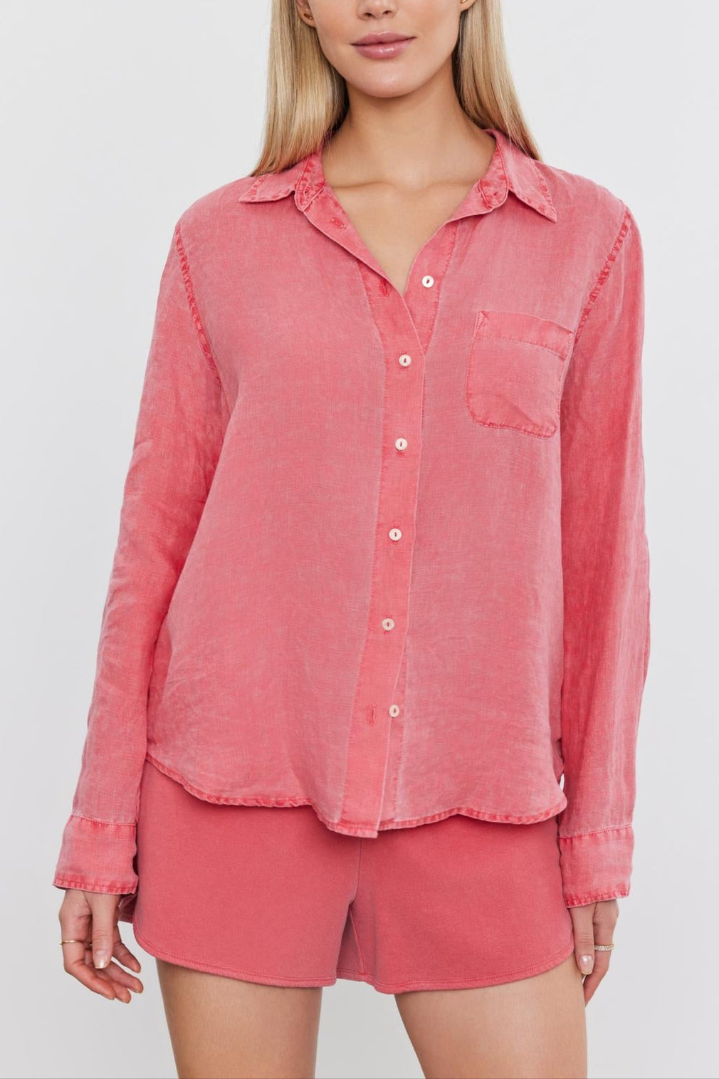 A woman in a Velvet by Graham & Spencer NATALIA LINEN BUTTON-UP SHIRT and matching shorts, standing against a white background.