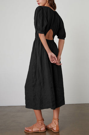 The back view of a woman wearing a Velvet by Graham & Spencer WHITNEY LINEN CUT OUT DRESS.