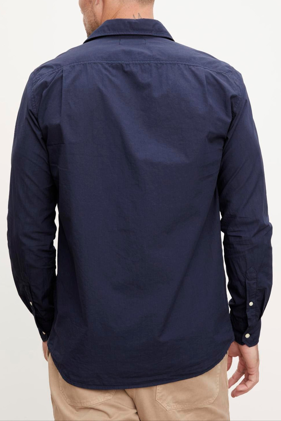 The back view of a man wearing the Velvet by Graham & Spencer BROOKS BUTTON-UP SHIRT and tan pants, showcasing his traditional trousers.-36009373302977