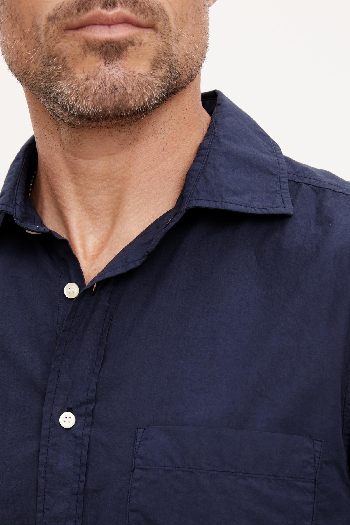 A man wearing a Velvet by Graham & Spencer BROOKS BUTTON-UP SHIRT and traditional trousers.-36009373237441