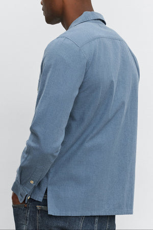 A man wearing the DONOVAN BUTTON-UP SHIRT by Velvet by Graham & Spencer and jeans stands facing away.