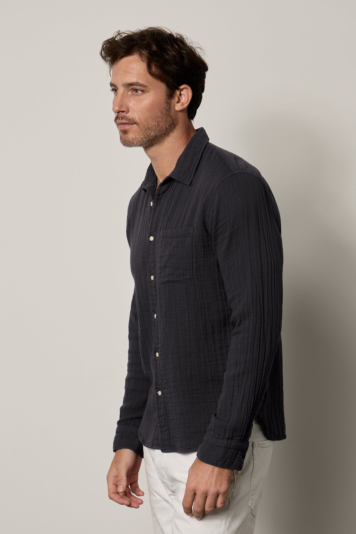 The model is wearing a ELTON BUTTON-UP SHIRT by Velvet by Graham & Spencer in navy and white pants.