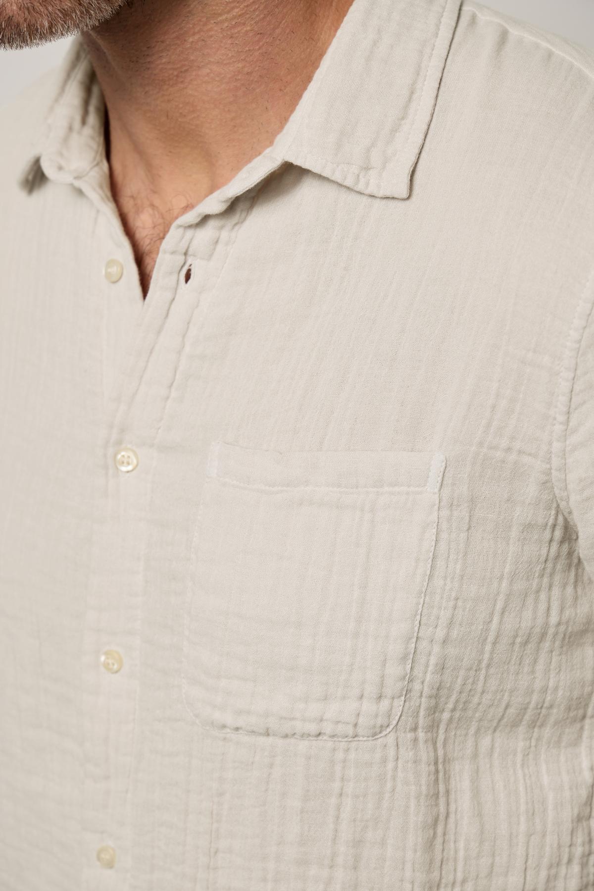 Close-up of a man in a Velvet by Graham & Spencer Elton Cotton Gauze Button-Up Shirt with a buttoned placket and a visible chest pocket.-36805210636481
