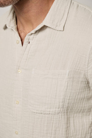 Close-up of a man in a Velvet by Graham & Spencer Elton Cotton Gauze Button-Up Shirt with a buttoned placket and a visible chest pocket.