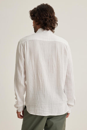A person with medium-length hair is wearing a Velvet by Graham & Spencer ELTON COTTON GAUZE BUTTON-UP SHIRT in white and green pants, seen from behind.