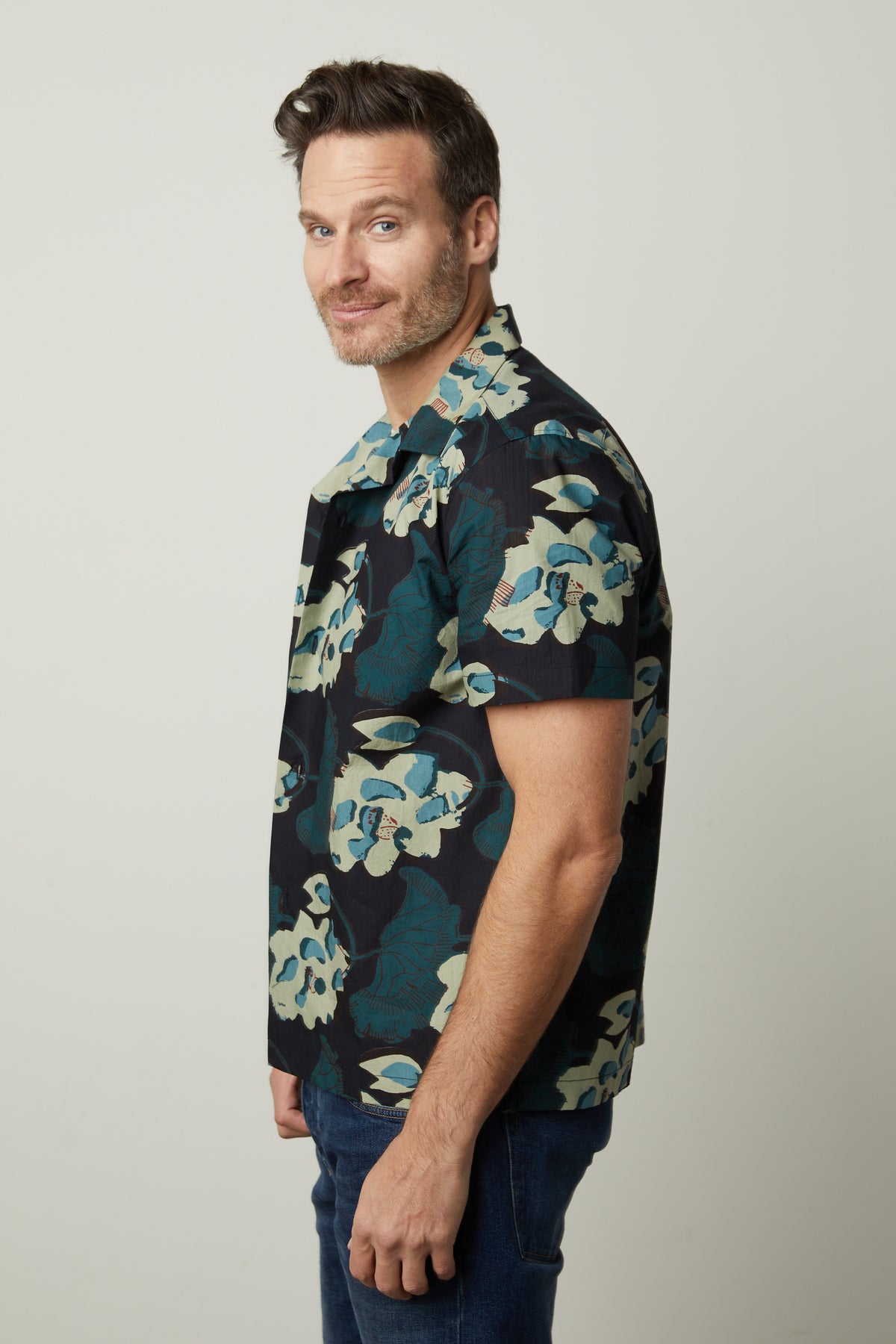A man wearing a Velvet by Graham & Spencer Iggy printed button-up shirt and jeans.-26679204970689