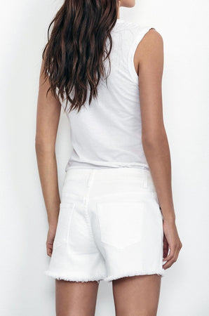 Person with long hair wearing a sleeveless white top and Velvet by Graham & Spencer's CINDY FRAYED HEM BOYFRIEND SHORTS, facing away from the camera.