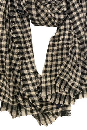 The SMALL CHECK SCARF by Velvet by Graham & Spencer features a classic black and white check pattern with frayed edges—an effortlessly stylish accessory to wrap around for any occasion.