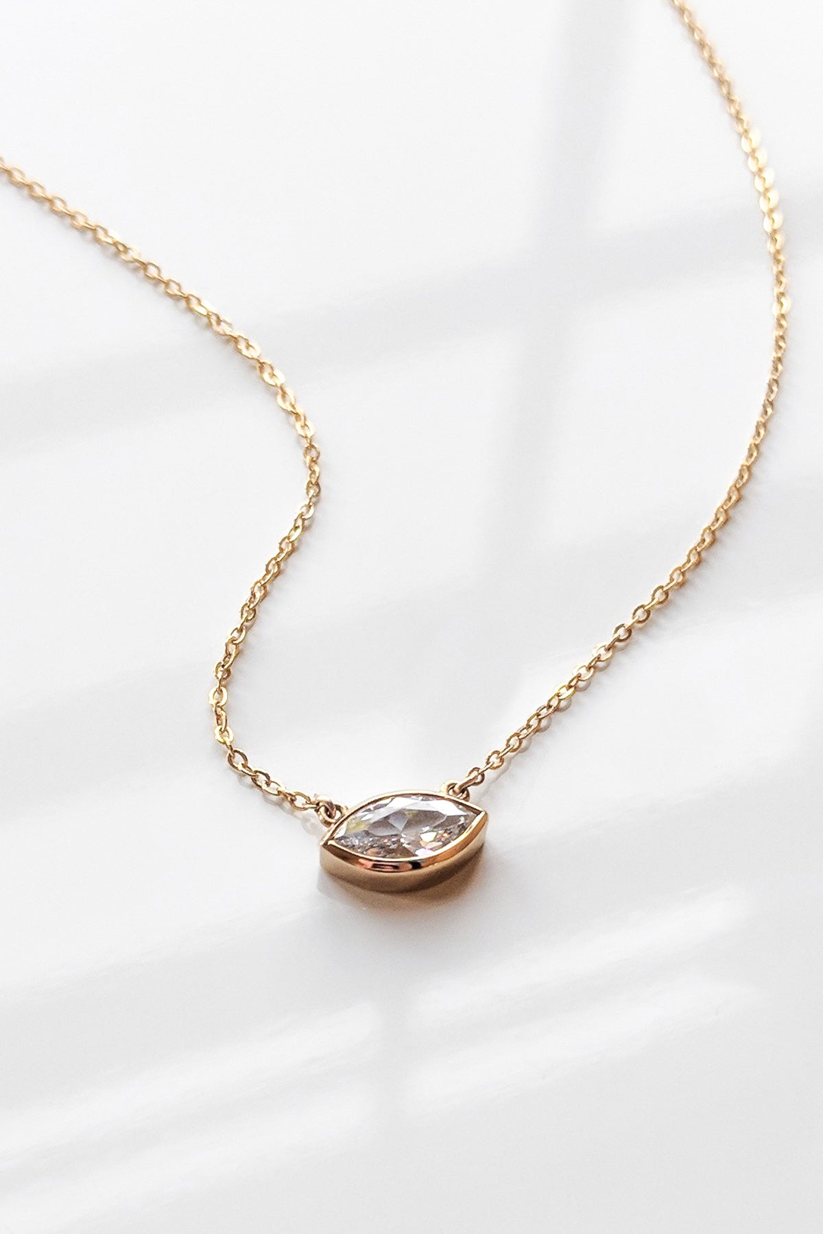 An IRIS NECKLACE BY THATCH, featuring a marquise CZ stone and a gold fill cable chain.-15203502817473