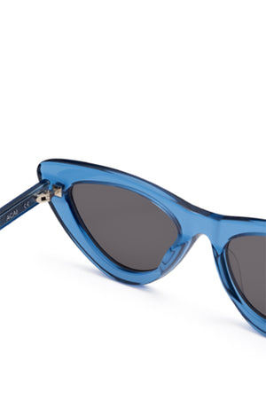 Close-up of 006 BY CHIMI EYEWEAR cat-eye sunglasses by Chimi, featuring blue frames and dark lenses. Stylish unisex shades set against a white background.