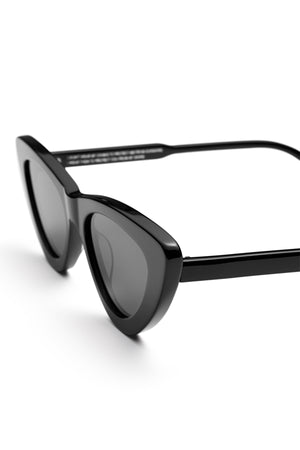 Chimi’s 006 BY CHIMI EYEWEAR: black unisex cat-eye sunglasses with dark lenses, shown angled on a white background—timeless shades crafted by Chimi.