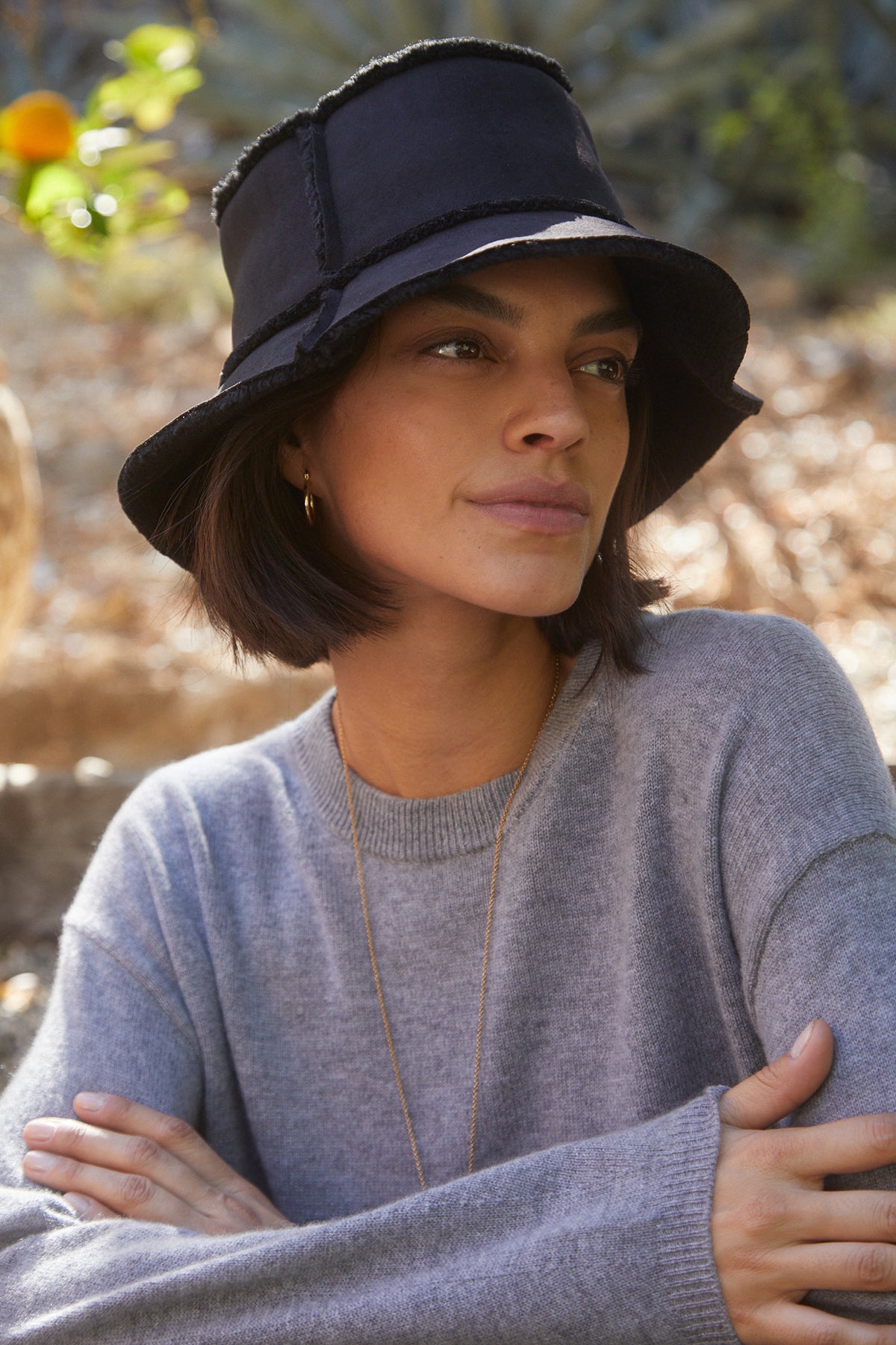 A woman wearing a REVERSIBLE FAUX SHEARLING BUCKET HAT by Velvet by Graham & Spencer.-25420285116609