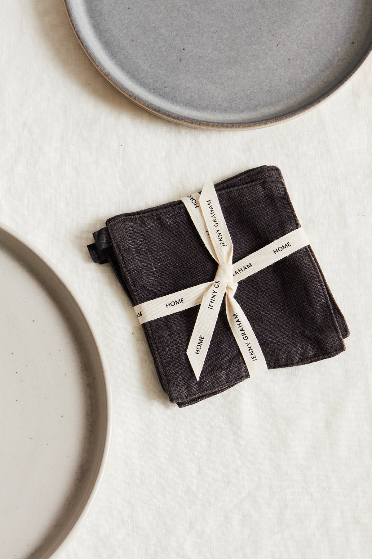 a set of LINEN COASTERS (SET OF 4) on a white surface, brand name Jenny Graham Home.-25629321068737