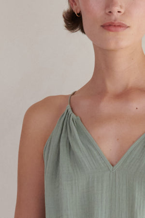 A close-up view of a woman wearing a Velvet by Jenny Graham Carrillo dress, focusing on the neckline and fabric detail.