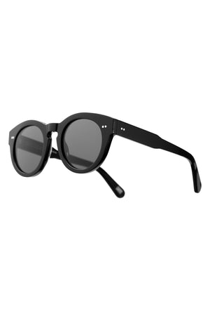CHIMI EYEWEAR 003 by Chimi—black round sunglasses with dark lenses and thick frames, shown angled on a white background. Modern unisex shades featuring standout European-made quality.