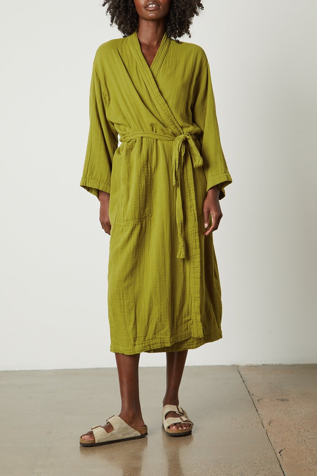 a woman wearing a green Cotton Gauze Robe from Jenny Graham Home and sandals.-25519573663937
