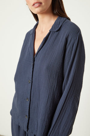 The model is wearing a blue PAJAMA SHIRT and pants by Jenny Graham Home.